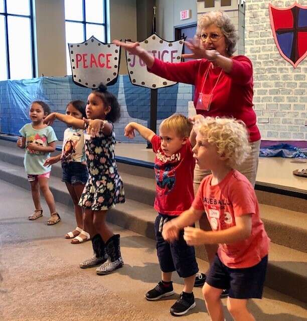 Some VBS students waving their hands and singing